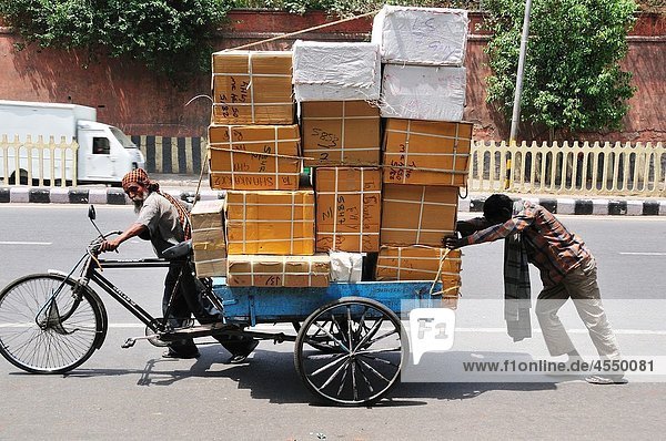 Two men carrying huge boxes  Delhi India