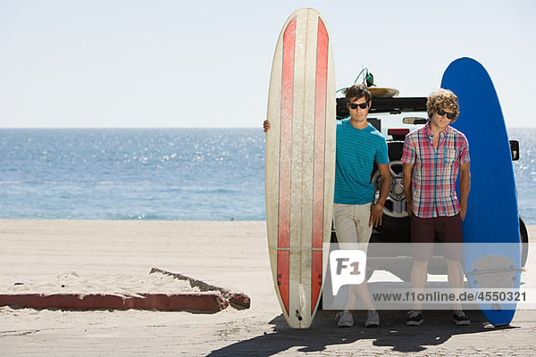 Two young men at coast with surfboards