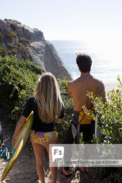 Young couple near the sea with surfboards