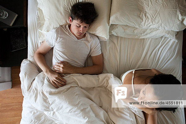 Mann schlafend und Frau unruhig im Bett