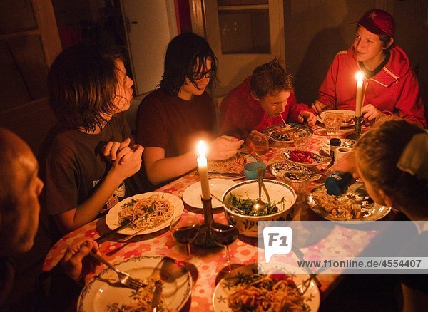 Familie mit jungen Essen bei Kerzenschein