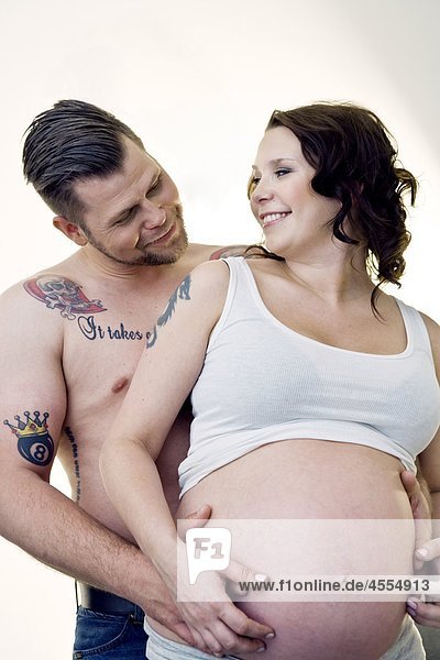 Mann Bauch rührende schwangere Frauen  lächelnd