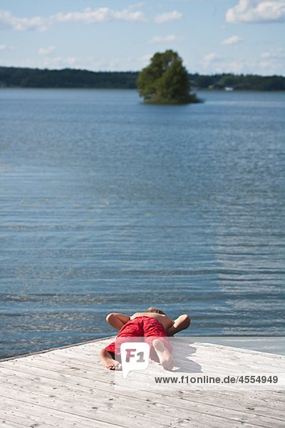 Boy am Pier und Blick auf See