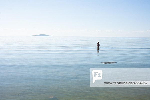 Silhouette of woman wading in sea