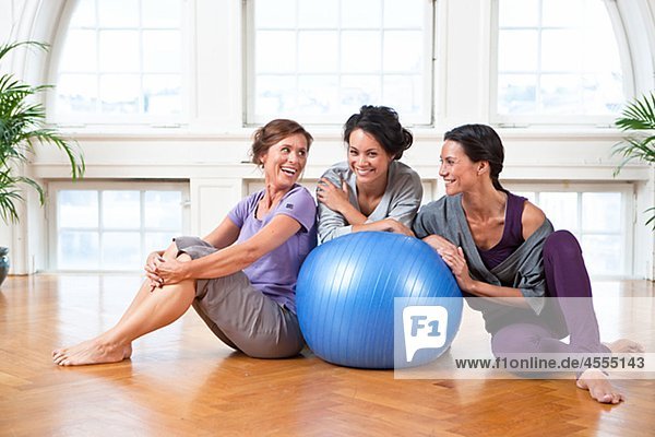 Drei Frauen mit Fitness-Ball im Fitness-Studio