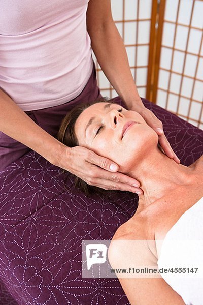 Woman having head massage at health spa