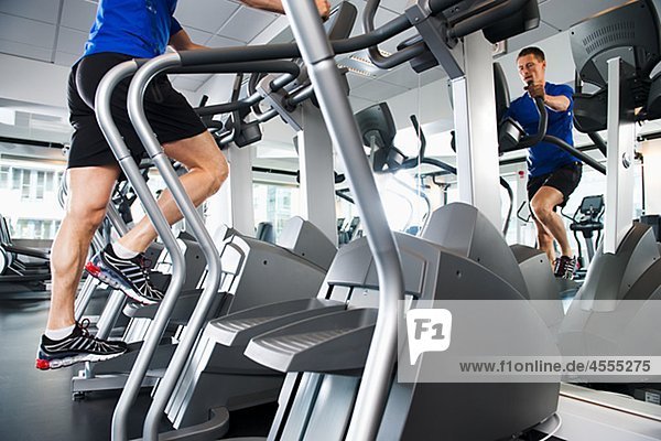 Man running on exercise machine in gym