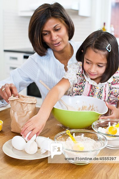 Mother baking with daughter in kitchen