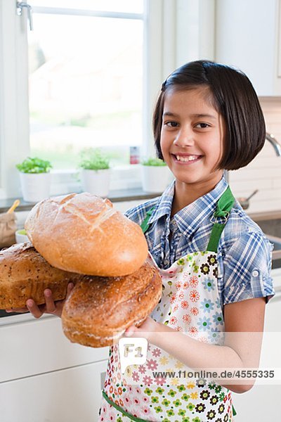Mädchen hält loafs Brot  Blick in die Kamera und lächelnd