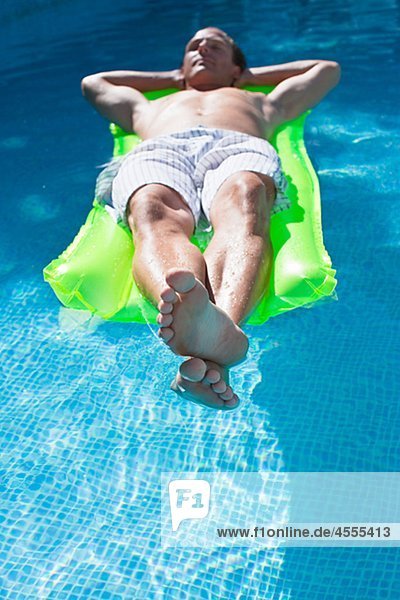 Man on inflatable raft in swimming pool