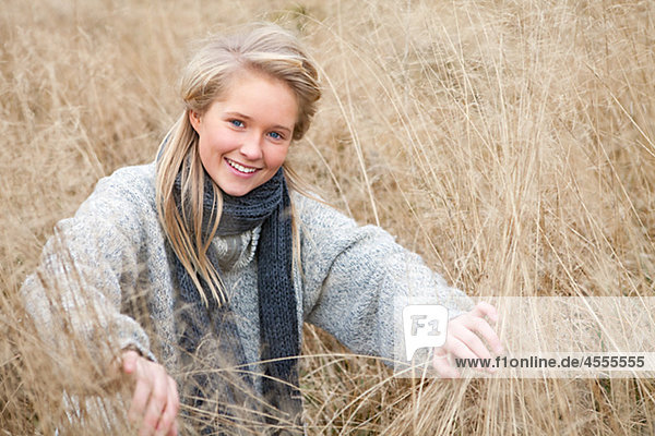 Portrait of teenage girl wearing scarf in field