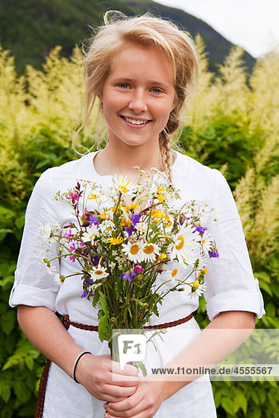 Portrait of teenage girl with bunch of flowers