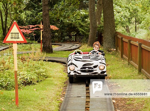 Boy riding car ride in amusement park