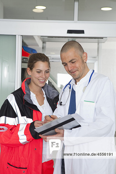 Paramedic and doctor examining file
