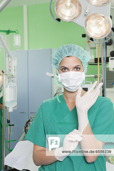 Krankenschwester im Kittel mit Handschuhen