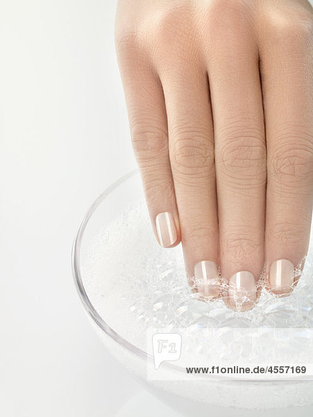Woman soaking fingernails  close-up