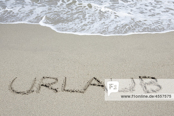 Das Wort Urlaub geschrieben im Sand Prunete Korsika