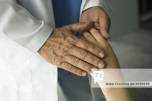 Arzt hält die Hand des Patienten