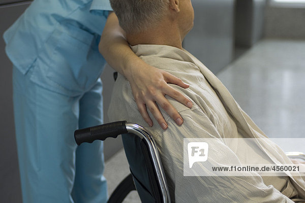 Krankenschwester hilft Patientin im Rollstuhl  abgeschnitten