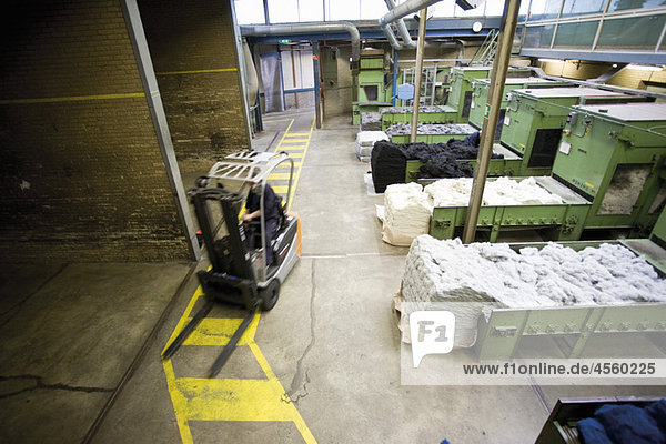 Teppichfliesenfabrik  Gabelstapler  der flauschige Fasern für die Verarbeitung vorbereitet