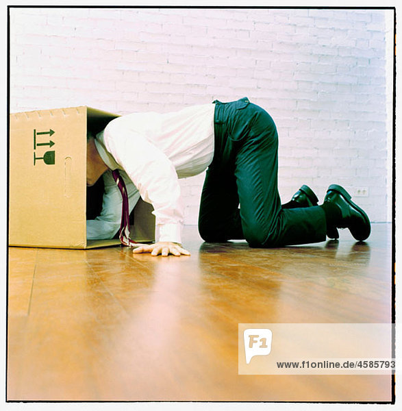 Businessman looking for something in a cardboard box