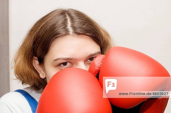 Young woman wearing red boxing gloves