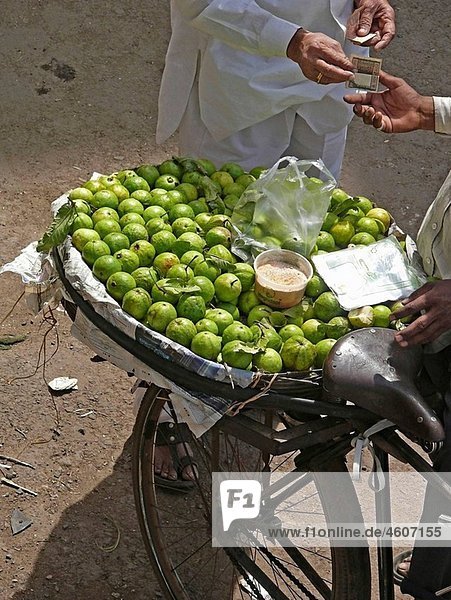 A man is paying after purchasing Guavas from a hawker
