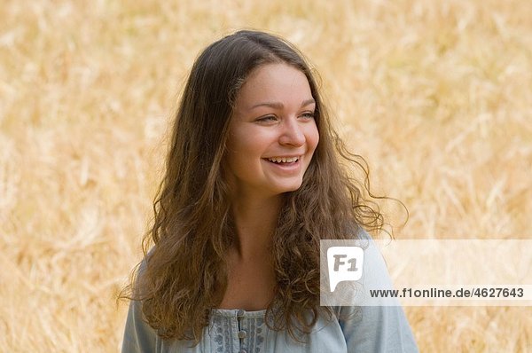 Teenager-Mädchen im Maisfeld  lächelnd
