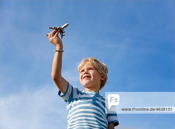 Junge (4-5 Jahre) spielt mit Spielzeugflugzeug