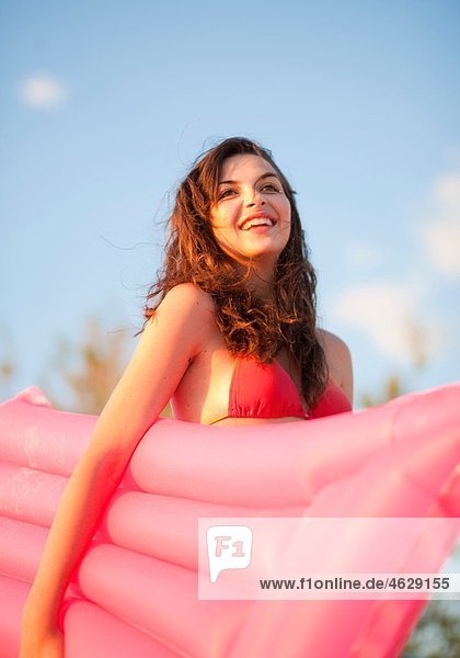 Kroatien  Zadar  Junge Frau mit Luftmatratze am Strand