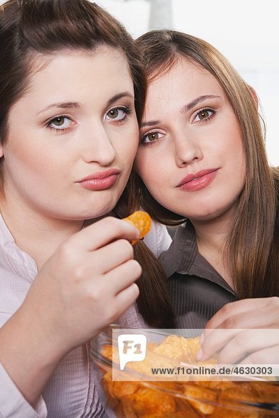 Junge Frauen essen Kartoffelchips