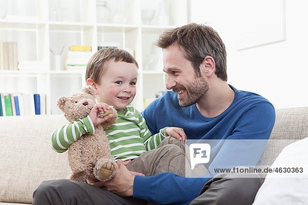 Deutschland  Bayern  München  Vater und Sohn (2-3 Jahre) mit Teddybär  lächelnd