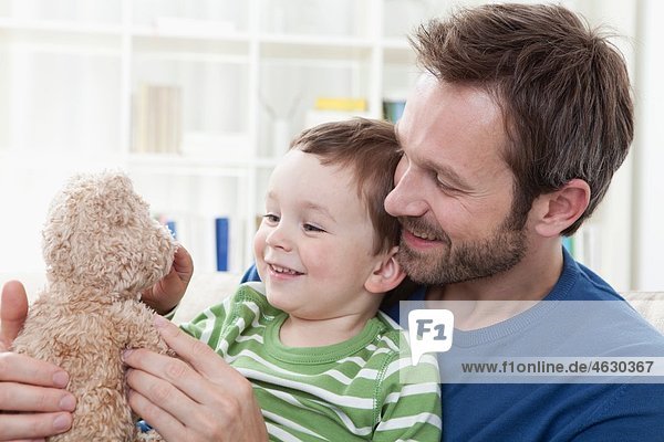 Deutschland  Bayern  München  Vater und Sohn (2-3 Jahre) mit Teddybär  lächelnd