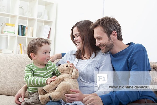 Eltern spielen mit Jungen (2-3 Jahre) im Wohnzimmer