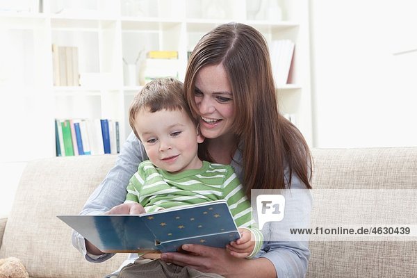 Deutschland  Bayern  München  Mutter und Sohn (2-3 Jahre) Lesebuch im Wohnzimmer