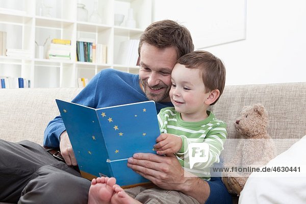 Vater und Junge (2-3 Jahre) beim Lesen eines Buches