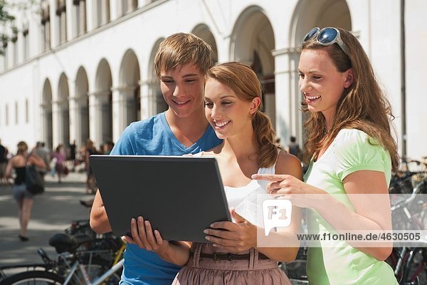 Young man and young women using laptop