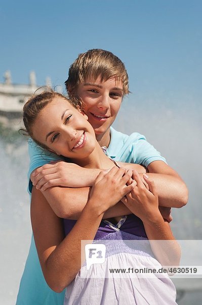 Young man embracing woman smiling  portrait