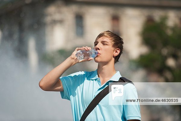 Young man drinking water from water bottle
