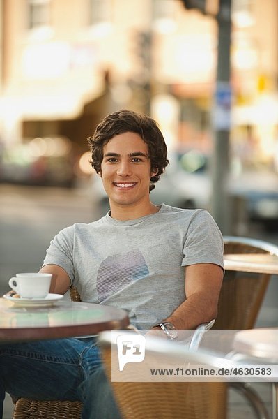 Young man in cafe  smiling  portrait