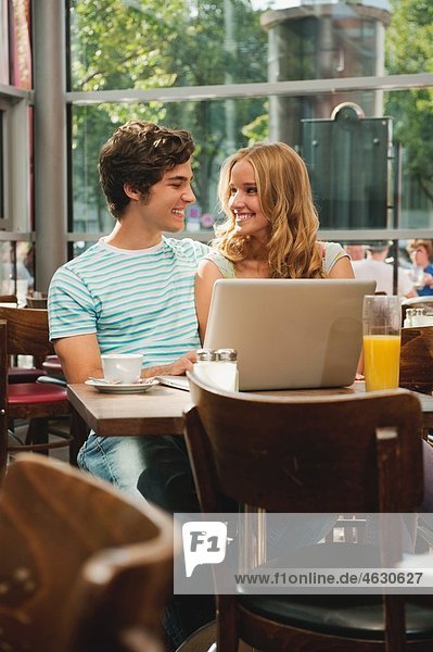 Deutschland  München  Paar mit Laptop im Cafe