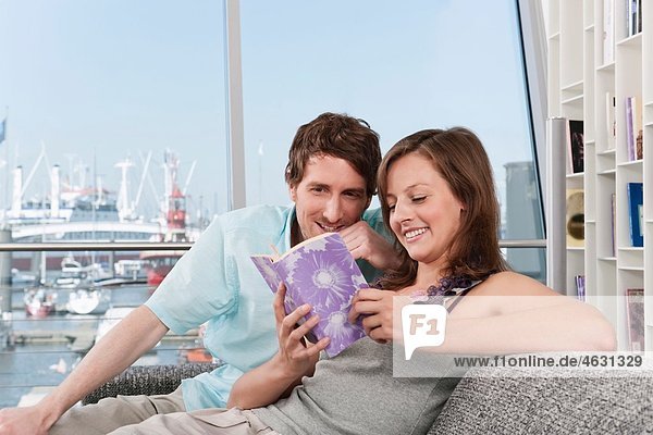 Man and woman reading book  smiling