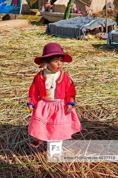 Children in traditional ethnic dress on the floating island of Uros on Lake Titicaca  Peru  South America