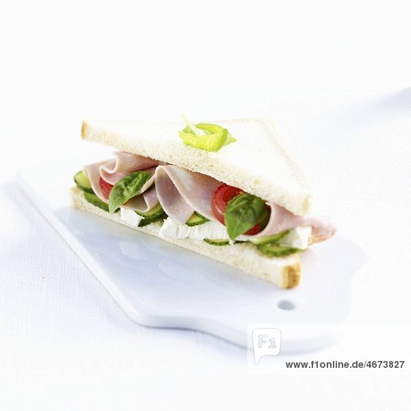 Sandwich mit Schinken  Camembert  Tomaten  Gurke und Basilikum