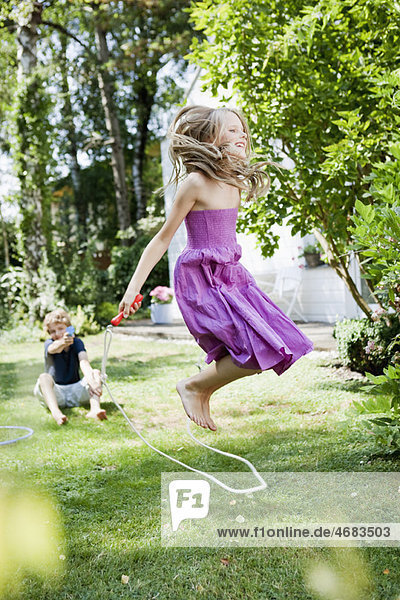 Girl jumping rope in garden