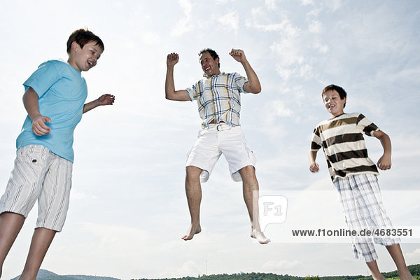 Vater und zwei Söhne springen