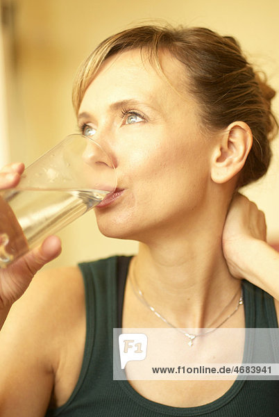 Frau trinkt Wasser zu Hause