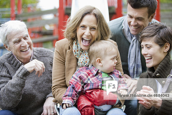 Familie mit Kind lacht im Park