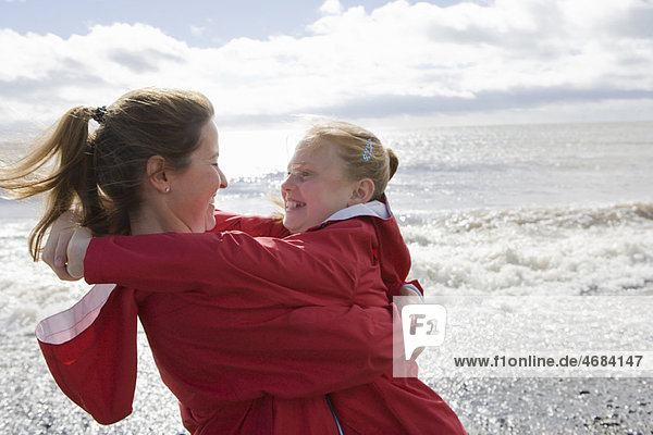 Mother and daughter hugging at beach