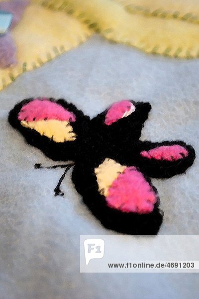 A black yellow and pink butterfly appliqued onto a fleece baby quilt